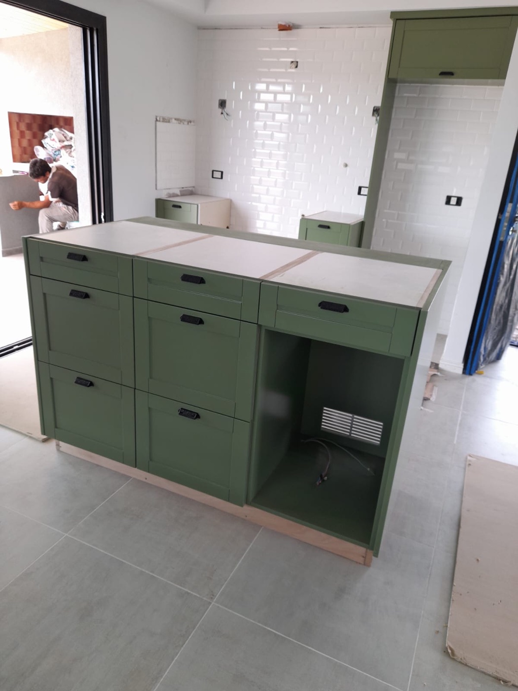 Isla de cocina en obra, terminación verde salvia