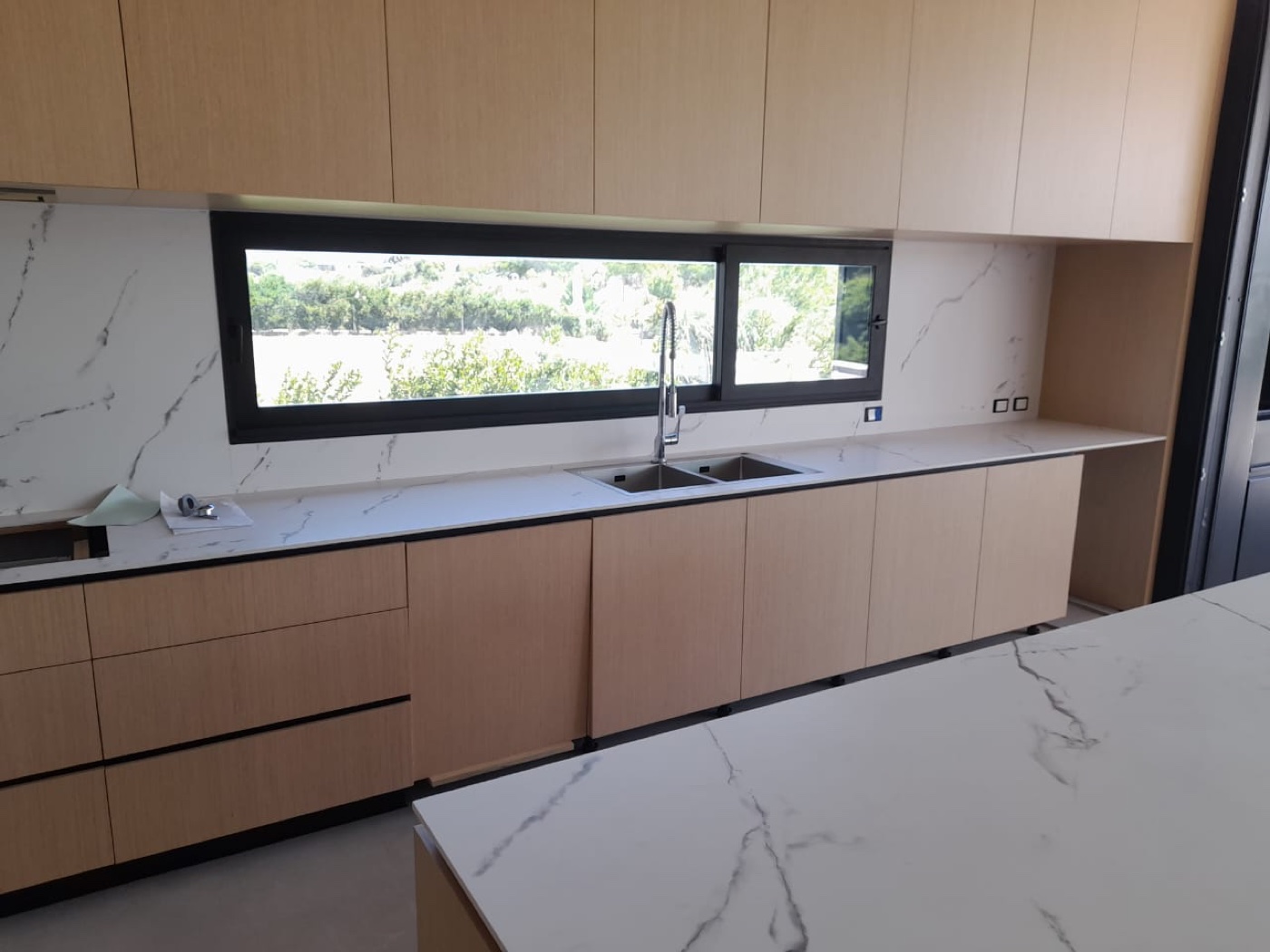 Cocina a medida con mesada de mármol, vista al jardín