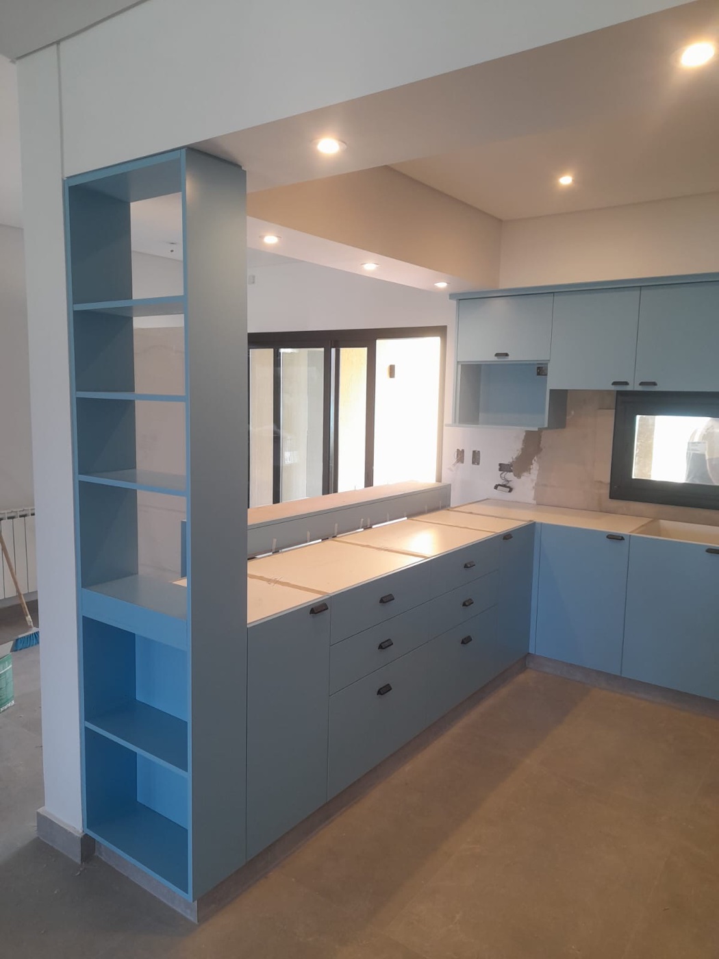 Cocina celeste con estantería pasante